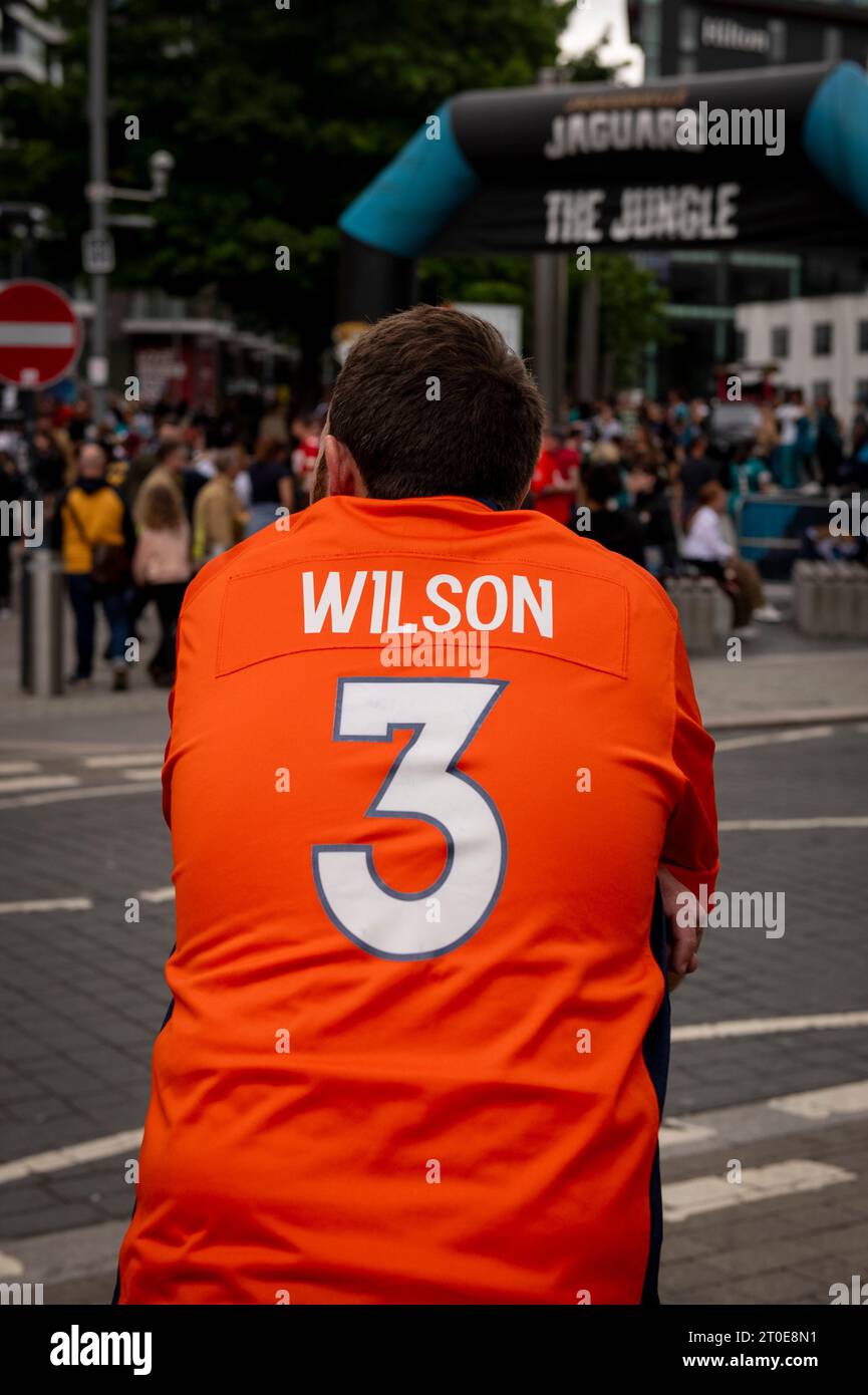 Un tifoso con Wilson 3 sul retro della sua maglia a guardare la folla riunirsi prima della partita NFL a Wembley Foto Stock