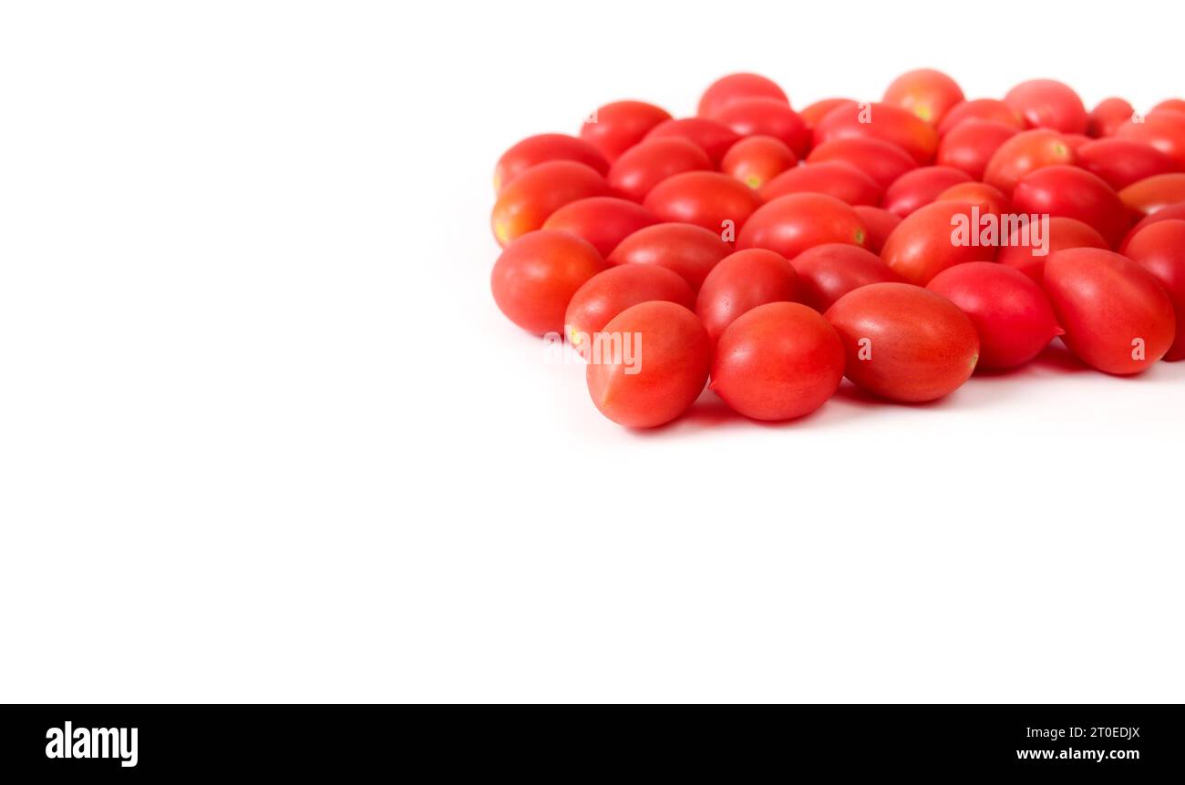 Pomodori ciliegini rossi maturi, isolati. Pomodori a bacca rossa appena raccolti dal giardino sul tetto. Pila di pomodori zuccherati. Messa a fuoco selettiva. Copia spa Foto Stock