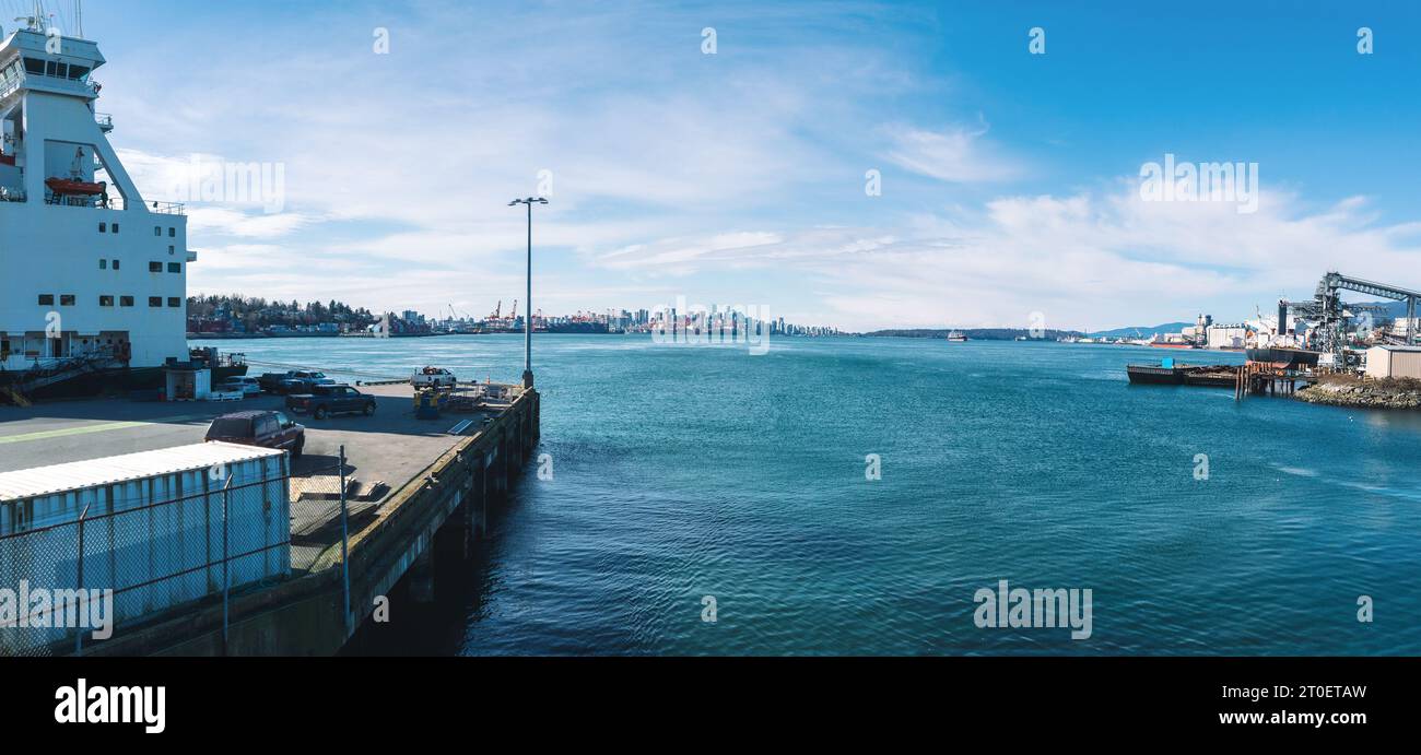 Vista panoramica del porto con vista sulla città in una giornata di sole. Paesaggio panoramico con cantieri navali cargo, industria marina e container shi Foto Stock