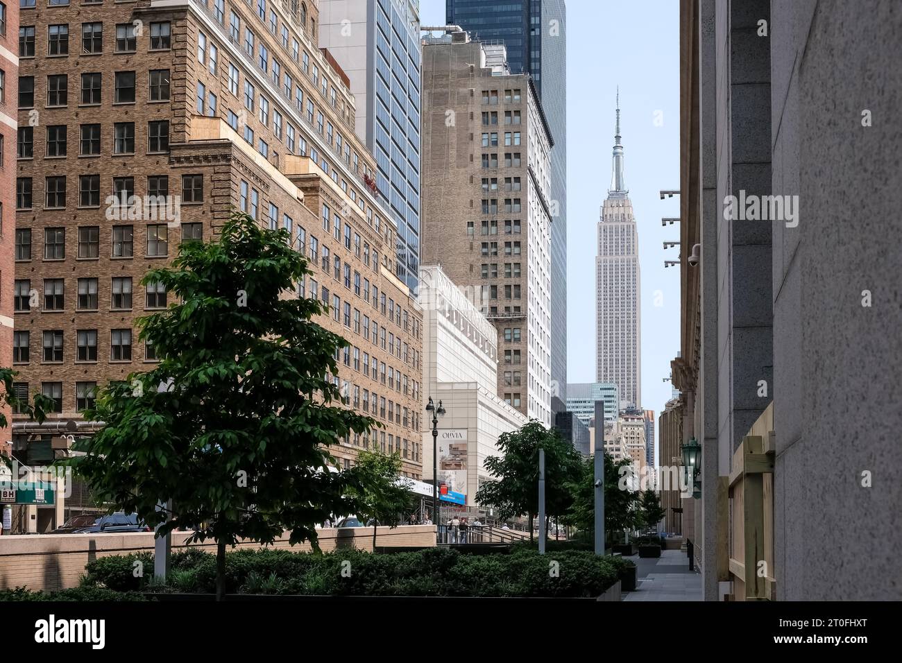 Vista della 33rd Street, la principale strada a crosstown nel quartiere di New York City a Manhattan, con l'Empire State Building sullo sfondo. Foto Stock