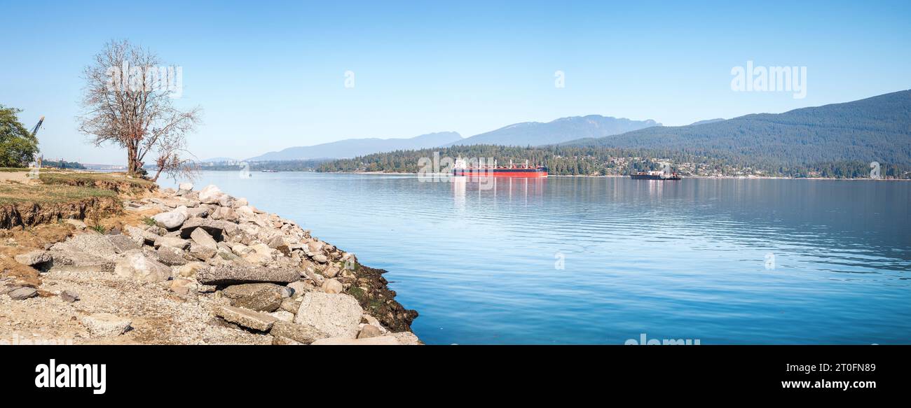 Nave da carico ancorata nell'insenatura di fronte alla zona montana. Panorama dei trasporti marittimi estivi. Burrard Inlet, Inner Harbour, Vancouver, British Columbia, Canada. Visualizza o Foto Stock