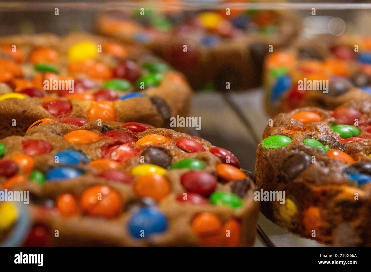 Caramelle arcobaleno come condimento per biscotti appena sfornati Foto Stock