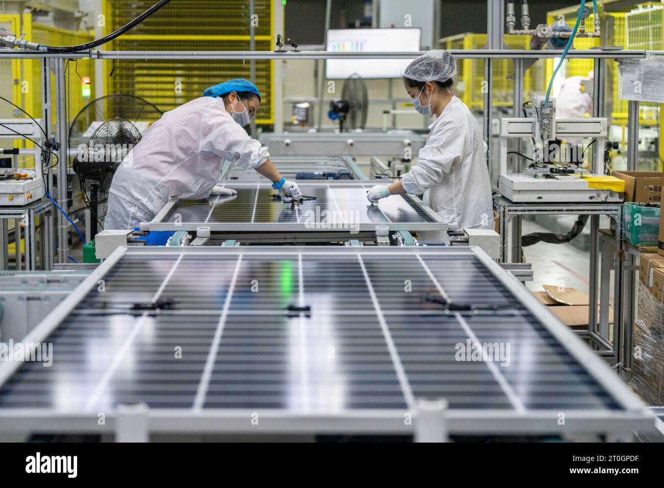 HEFEI, CINA - 7 OTTOBRE 2023 - due lavoratori producono prodotti fotovoltaici solari in un workshop di produzione di moduli fotovoltaici di New Energy Technology Foto Stock