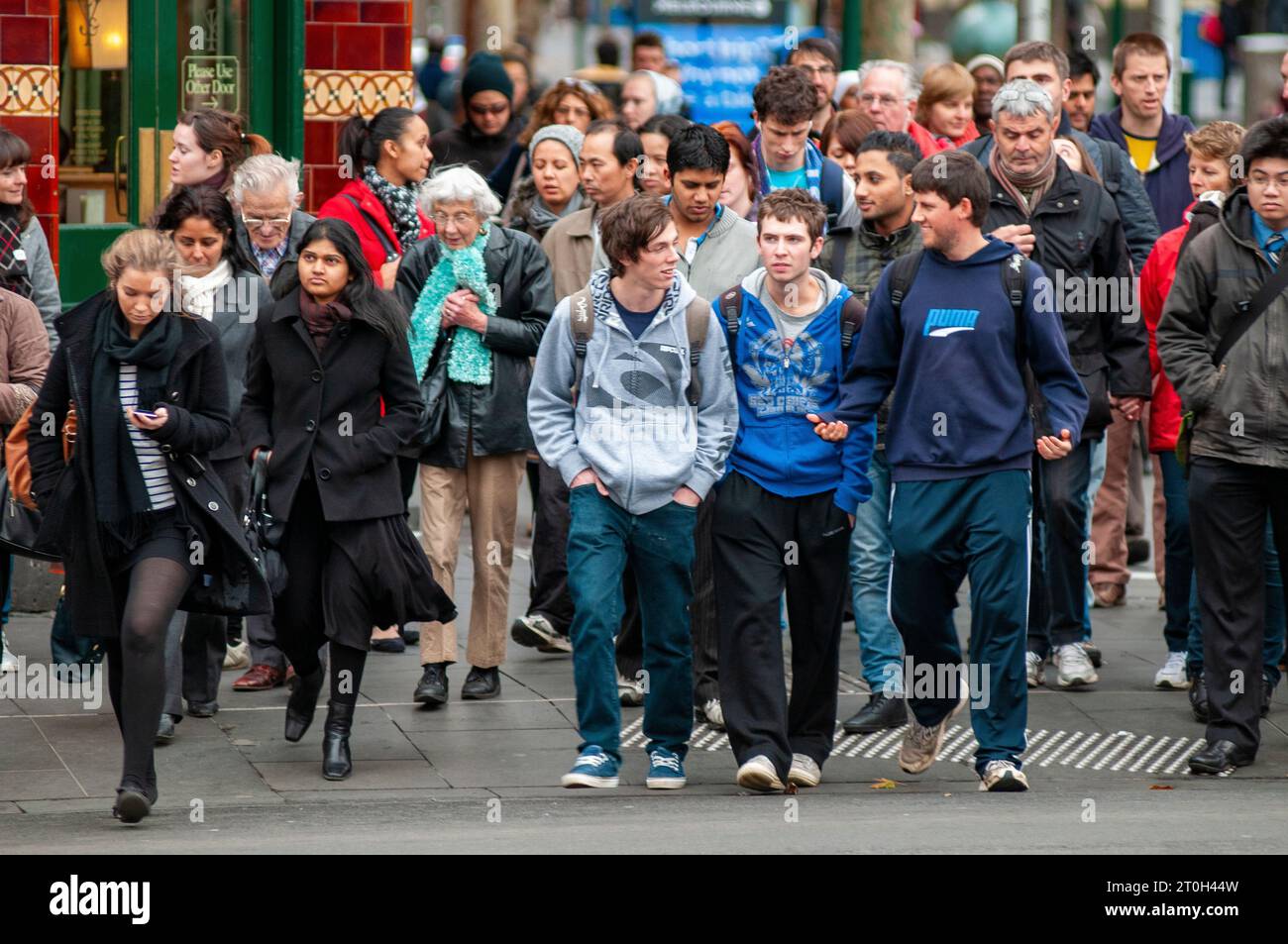 Pendolari diretti a casa all'attraversamento pedonale fuori dalla stazione di Flinders Street a Melbourne, Australia Foto Stock