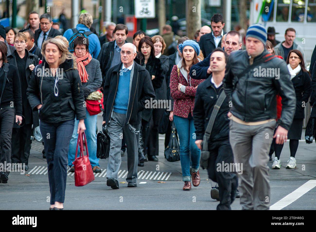 Pendolari diretti a casa all'attraversamento pedonale fuori dalla stazione di Flinders Street a Melbourne, Australia Foto Stock