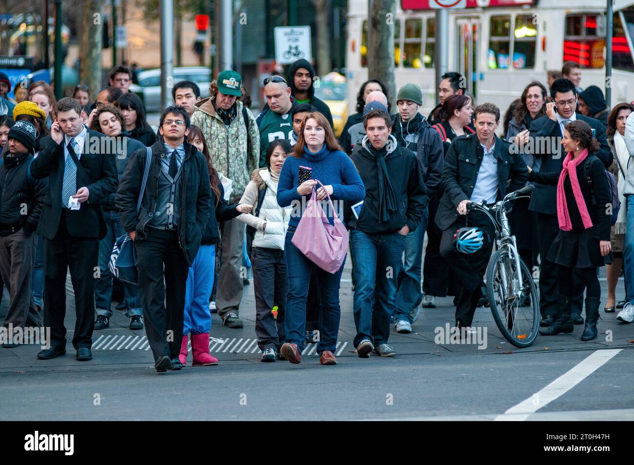 Pendolari diretti a casa all'attraversamento pedonale fuori dalla stazione di Flinders Street a Melbourne, Australia Foto Stock