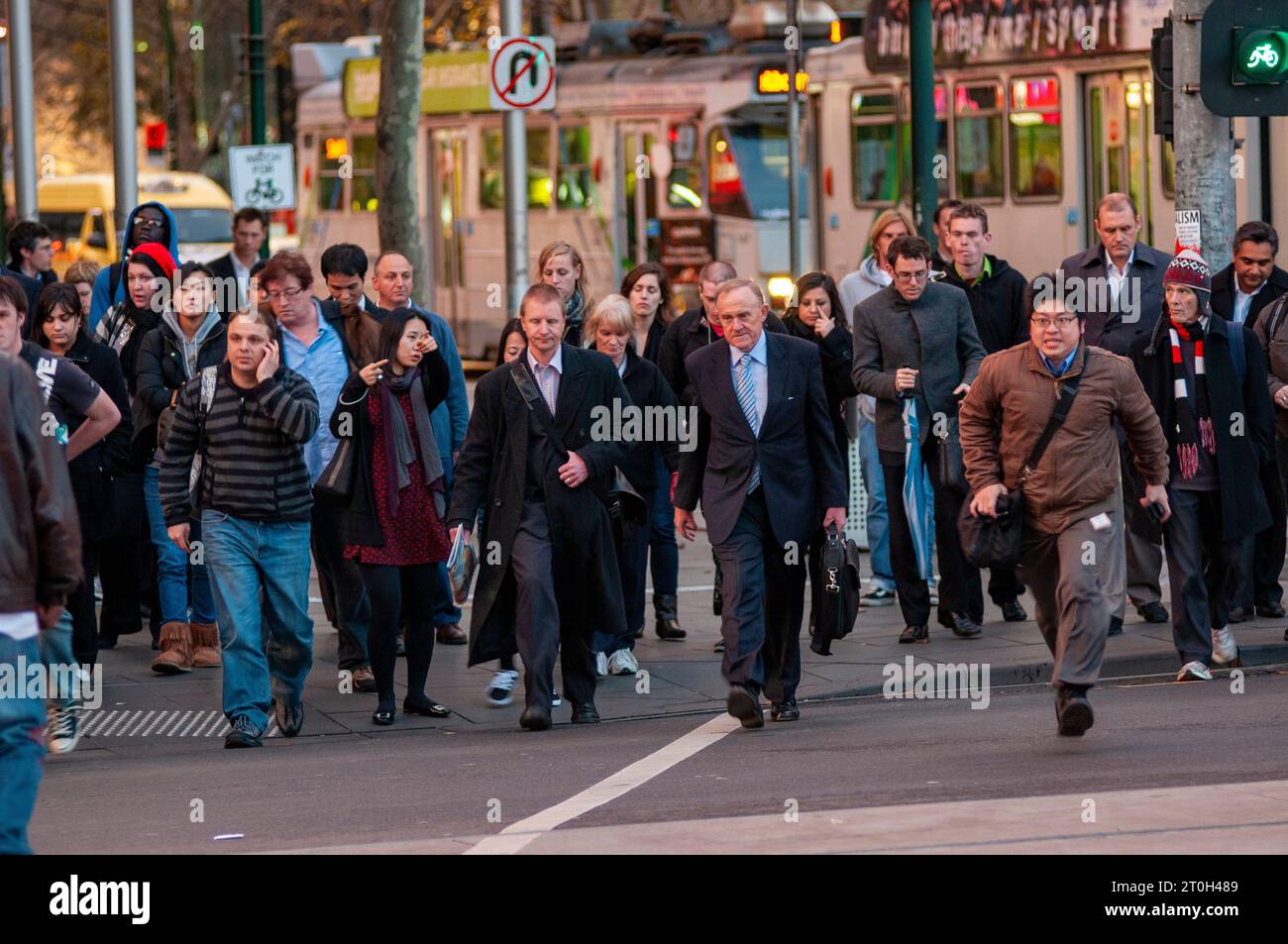 Pendolari diretti a casa all'attraversamento pedonale fuori dalla stazione di Flinders Street a Melbourne, Australia Foto Stock