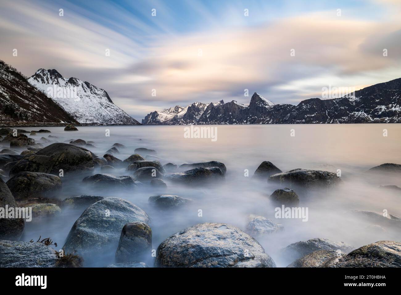 Montagne innevate vicino al fiordo, vicino a Mefjordbotn, Mefjorden, Senja Island, Norvegia Foto Stock