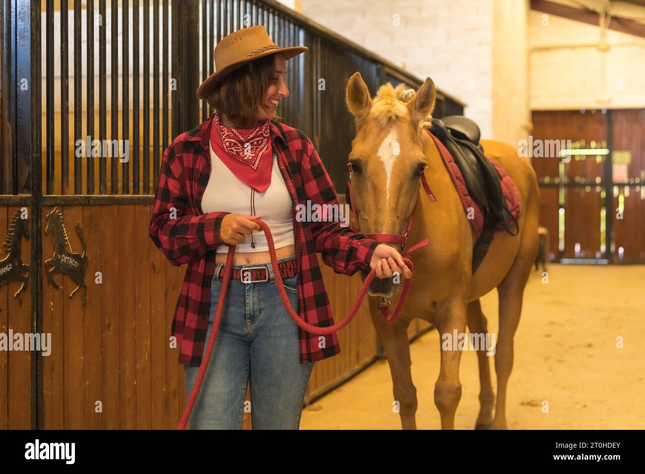 Uomo con camicia e cappello da cowboy che scatta foto con il cellulare  durante il trekking in montagna