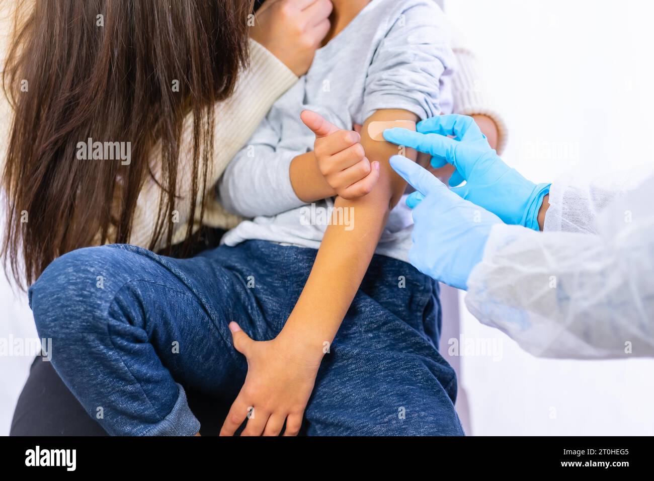 Bambino spaventato dopo l'iniezione di vaccinazione da parte di un medico femminile. Vaccinazione dei bambini. Immunizzazione nella pandemia di coronavirus, covid-19 Foto Stock