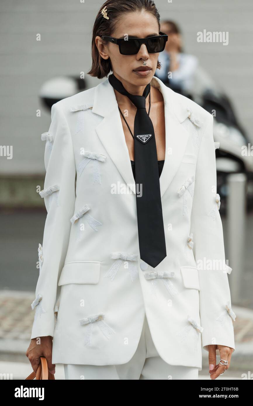 Un ospite indossa pantaloni bianchi, cravatta Prada nera, sandali con plateau neri e borsa visibili all'esterno della sfilata PRADA durante la primavera dell'abbigliamento donna della settimana della moda di Milano Foto Stock