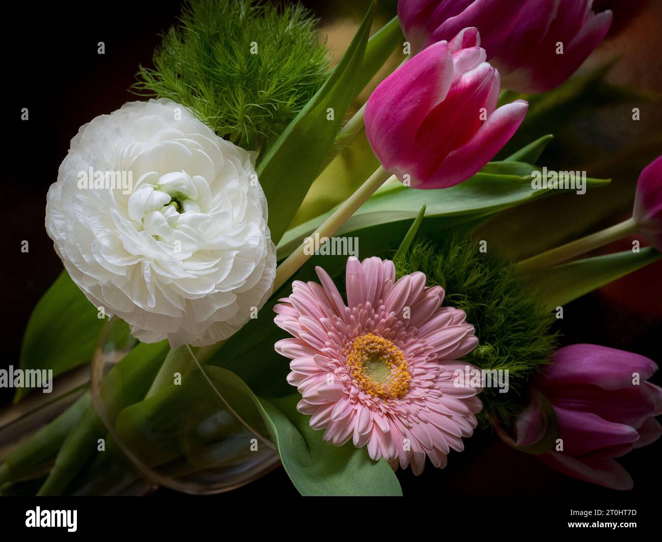 Un'elegante disposizione di vari fiori in un sofisticato vaso Foto Stock