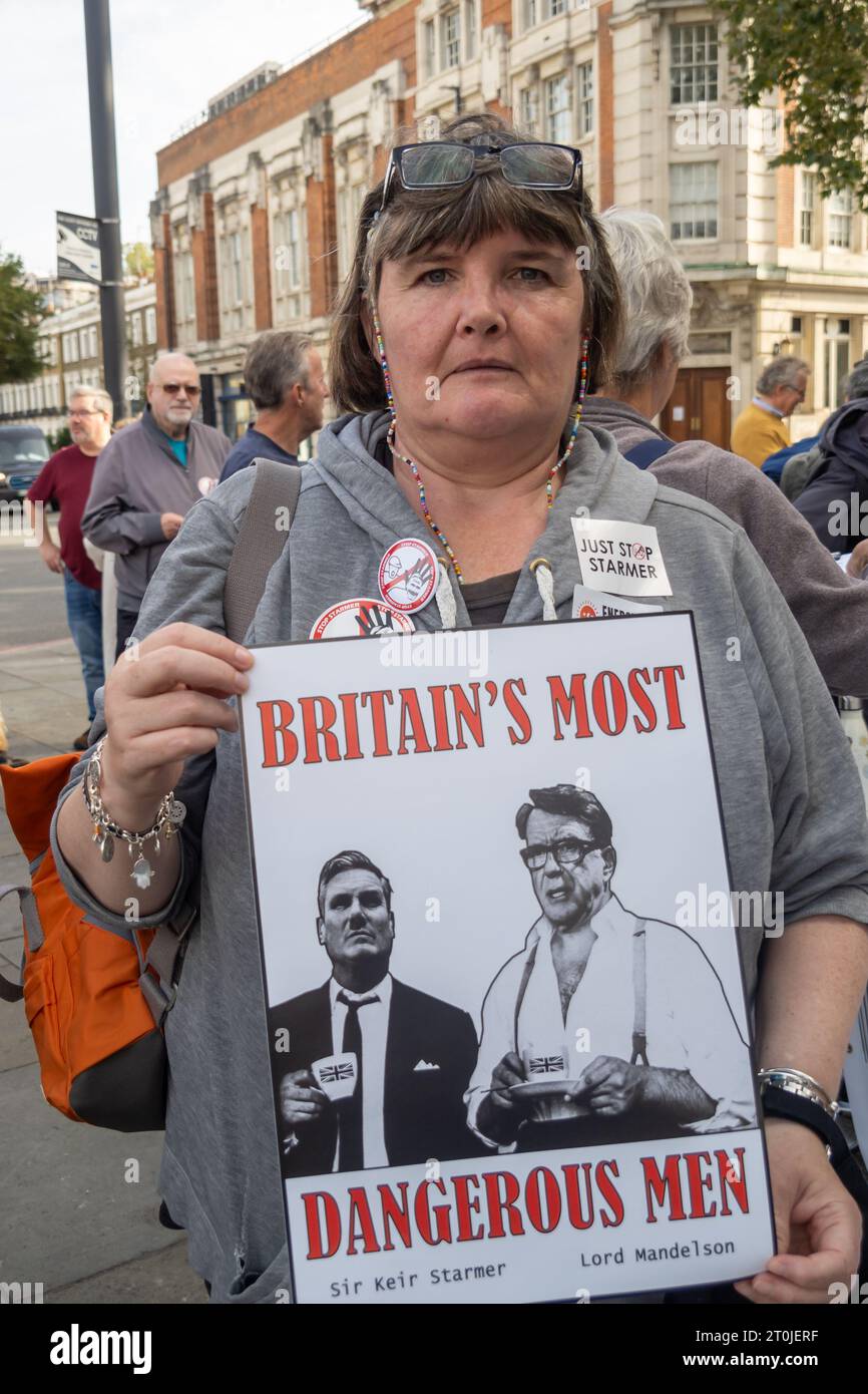 Londra, Regno Unito. 7 ottobre 2023. Un giorno prima della conferenza laburista, la gente si incontra nel collegio elettorale di Keir Starmer per avvertire tutti quanto sarebbe pericoloso un governo guidato da Starmer. Tra i presenti vi erano molti ex membri del partito laburista che affermano di non avere principi e elencano quasi 30 impegni che ha finora rinunciato, tra cui lavori verdi, esternalizzazione del servizio sanitario nazionale, riforma dei signori, pasti scolastici gratuiti, diritti dei lavoratori, contratti petroliferi, PR, assistenza all'infanzia. Paula Peters del DPAC tiene un poster. Peter Marshall/Alamy Live News Foto Stock