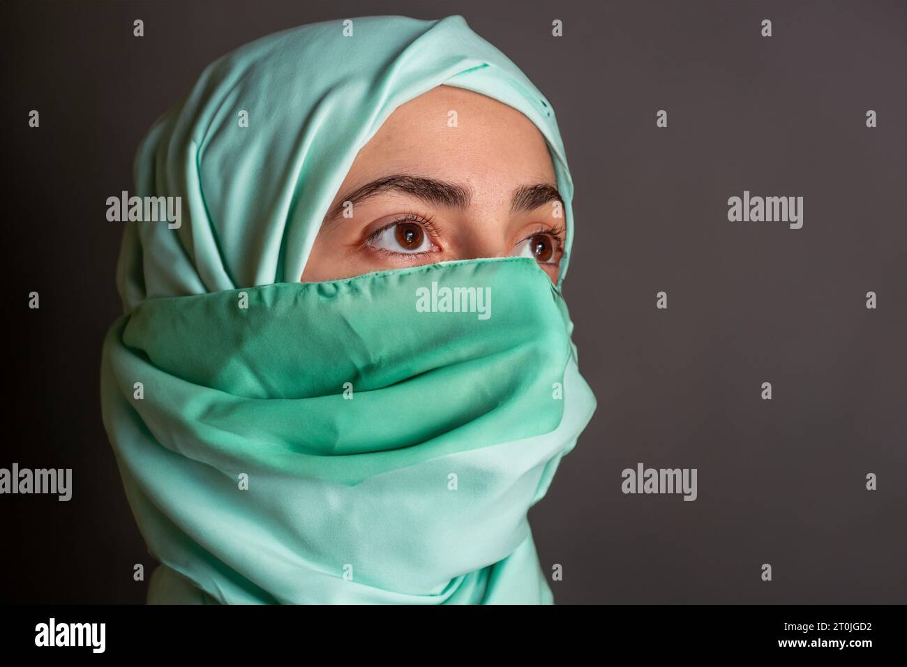 Donna musulmana che indossa una maschera e prega allah per proteggerla dalle malattie Foto Stock