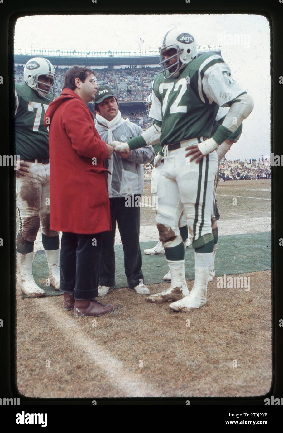 Il dottor Robert Grossman, ortopedista e medico di squadra dei New York Jets, controlla la salute della linemanaal Woods, mentre il lineman Gary Puetz guarda. Ai margini di una partita di football del 1976 allo Shea Stadium di New York. Grossman faceva parte dello staff dell'Institute of Sports Medicine and Athletic Trauma. Foto Stock