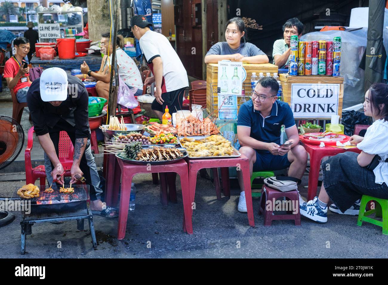 Hoi An, Vietnam. Fornitori e clienti di alimentari di strada notturni. Foto Stock