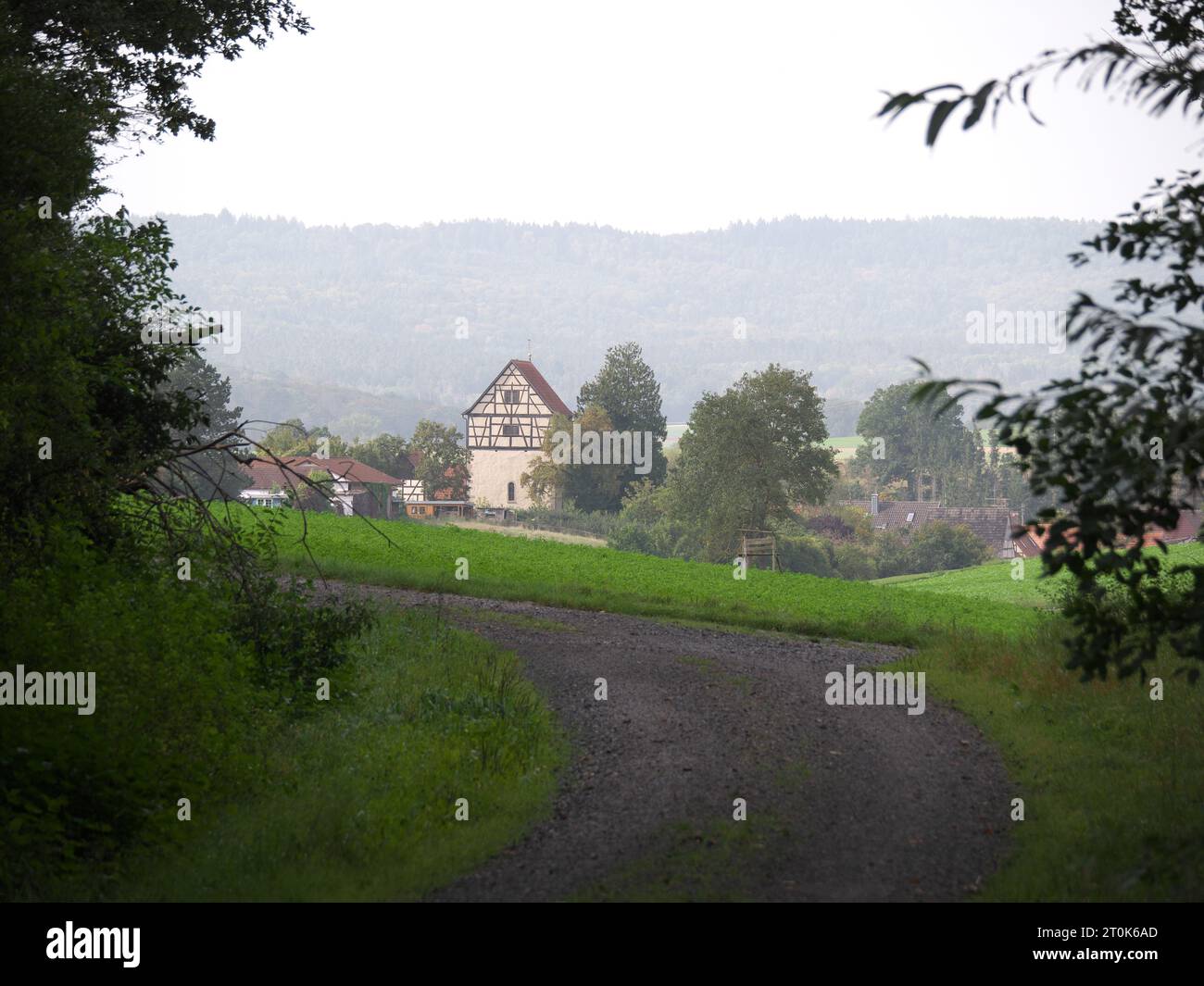 Idilliaca casa a graticcio sorge da un villaggio alla fine di un sentiero Foto Stock