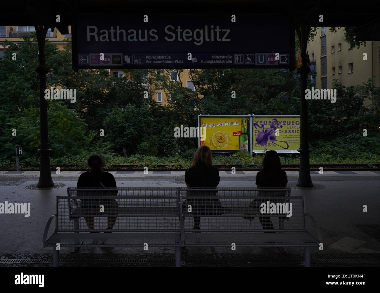 Tre donne in attesa alla stazione ferroviaria di Rathaus Steglitz, Berlino Foto Stock