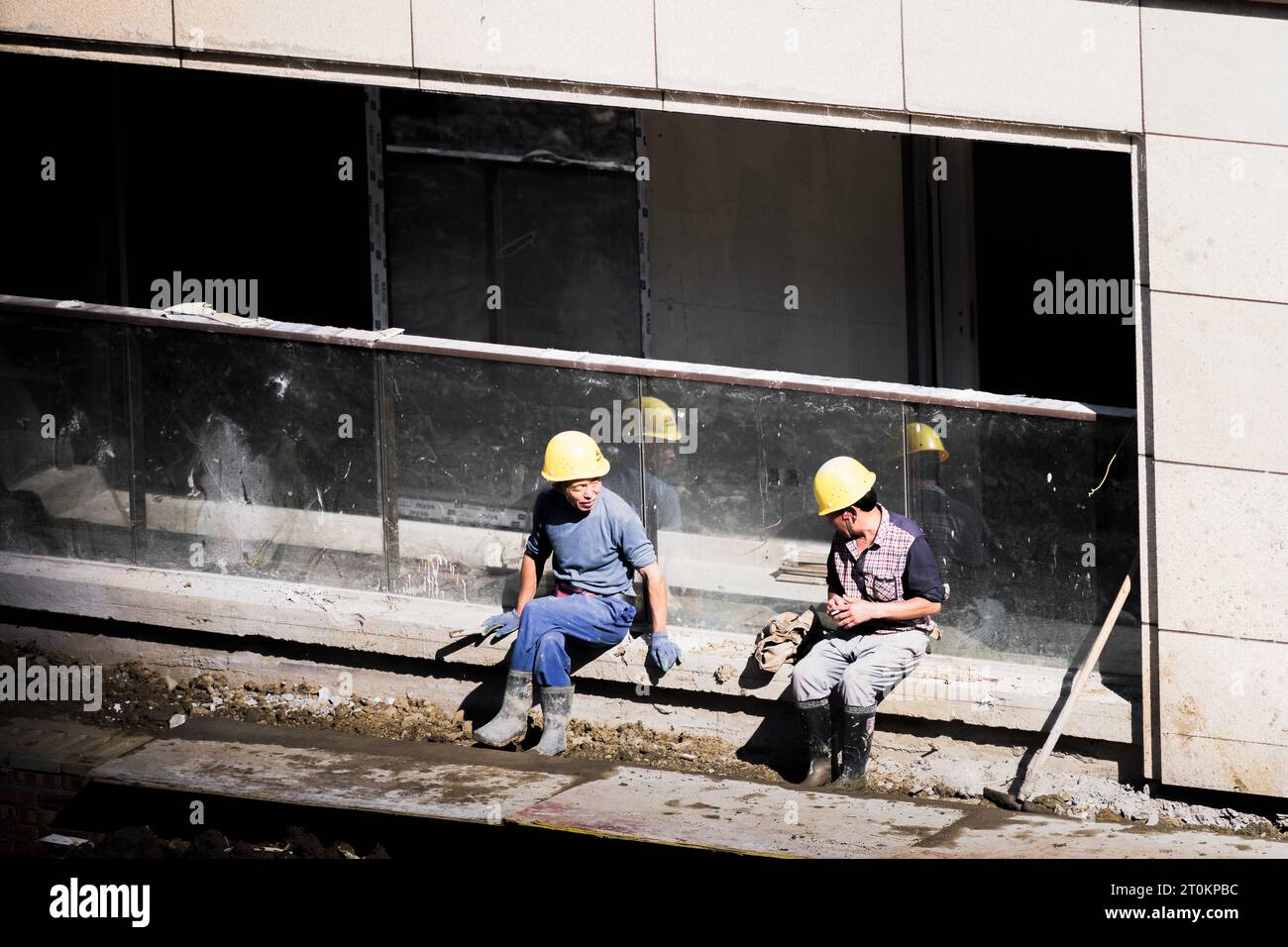 In una giornata di sole, gli operai edili fanno una pausa accanto all'edificio in costruzione. Foto Stock