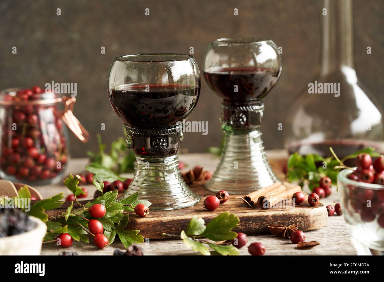 Vino medicinale a base di bacche di biancospino selvatico in tazzine di cosiddetto vetro forestale contenente bolle Foto Stock