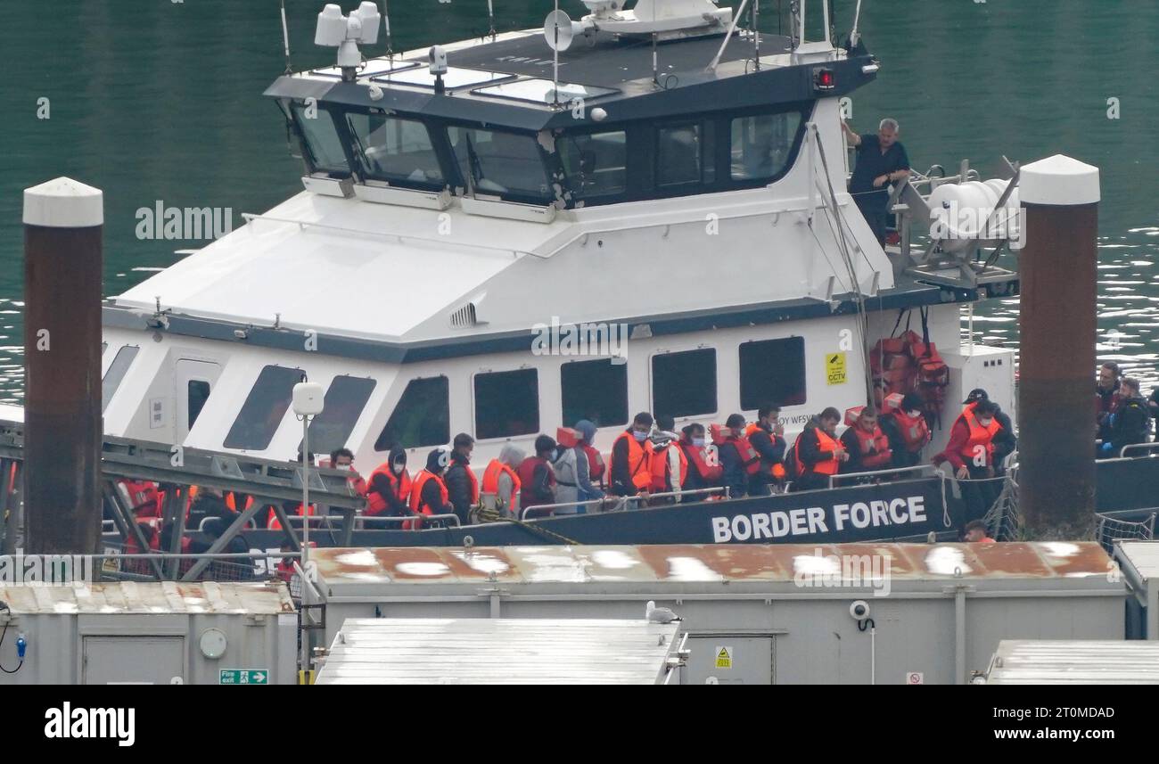 Foto del fascicolo datata 02/10/23 di un gruppo di persone che si pensa siano migranti vengono portati a dover, nel Kent, da un vascello della Border Force a seguito di un piccolo incidente in barca nel Canale. Il controllo della Corte Suprema sui piani del governo di deportare i richiedenti asilo arriva quasi 18 mesi dopo che sono stati annunciati per la prima volta. Le continue battaglie legali hanno fatto sì che non ci siano ancora stati migranti inviati nella nazione dell'Africa orientale nell'ambito della politica. Nel frattempo, la crisi dei migranti della Manica continua in mezzo a un dibattito politico. Data di emissione: Lunedì 9 ottobre 2023. Foto Stock