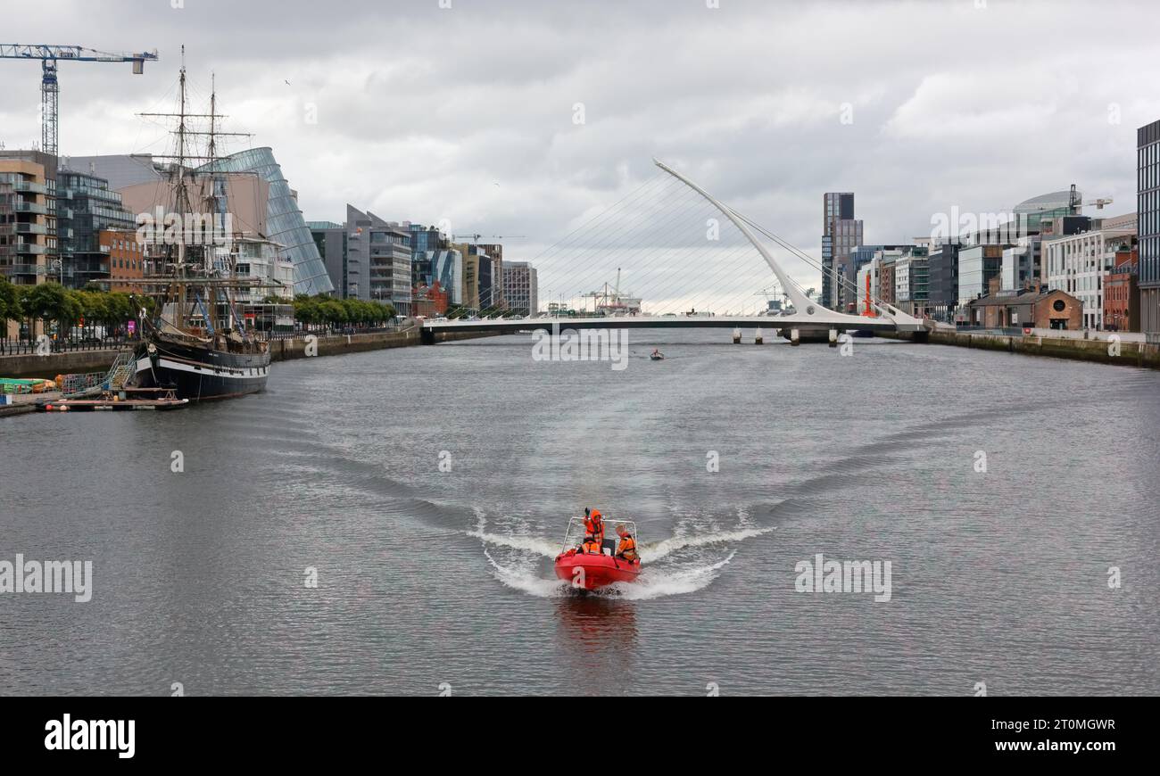 DUBLINO, Irlanda - 3 agosto 2023 - barca di gomma arancione che viaggia lungo il fiume Liffey sui Docklands in una fredda giornata estiva Foto Stock