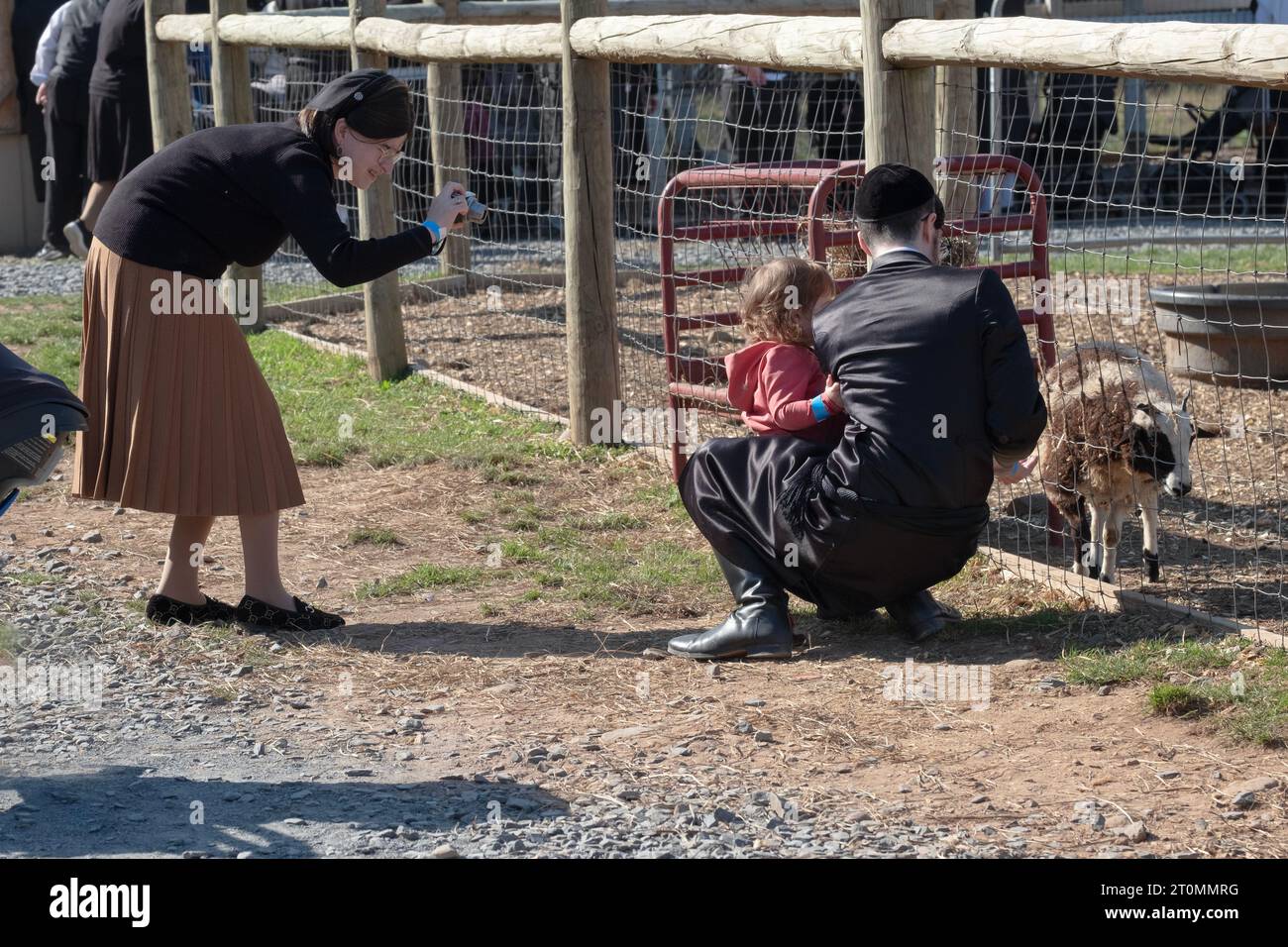 Una famiglia ebrea ortodossa celebra Sukkos visitando uno zoo di animali domestici e un luogo divertente per i bambini. A Monsey, New York. Foto Stock