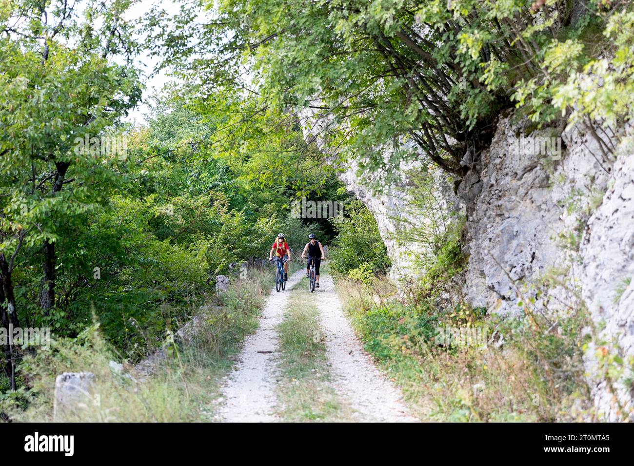 Madre e figlio, turisti in un viaggio in bicicletta nella campagna intorno a Pivka, in bicicletta sulla vecchia strada militare italiana costruita prima della prima guerra mondiale, in slovenia Foto Stock