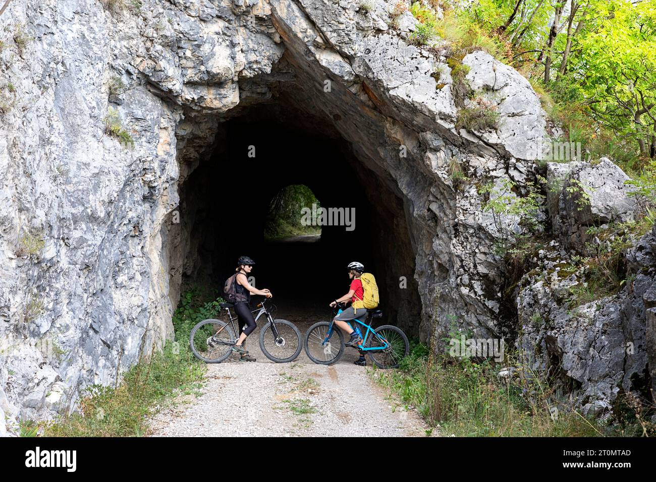 Madre e figlio, turisti in gita in bicicletta con mtb nella campagna intorno a Pivka, all'ingresso dell'antico tunnel militare italiano, in slovenia Foto Stock