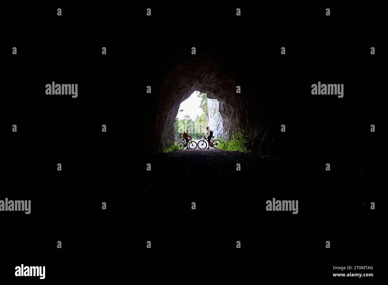 Madre e figlio, turisti in gita in bicicletta con mtb nella campagna intorno a Pivka, all'ingresso dell'antico tunnel militare italiano, in slovenia Foto Stock