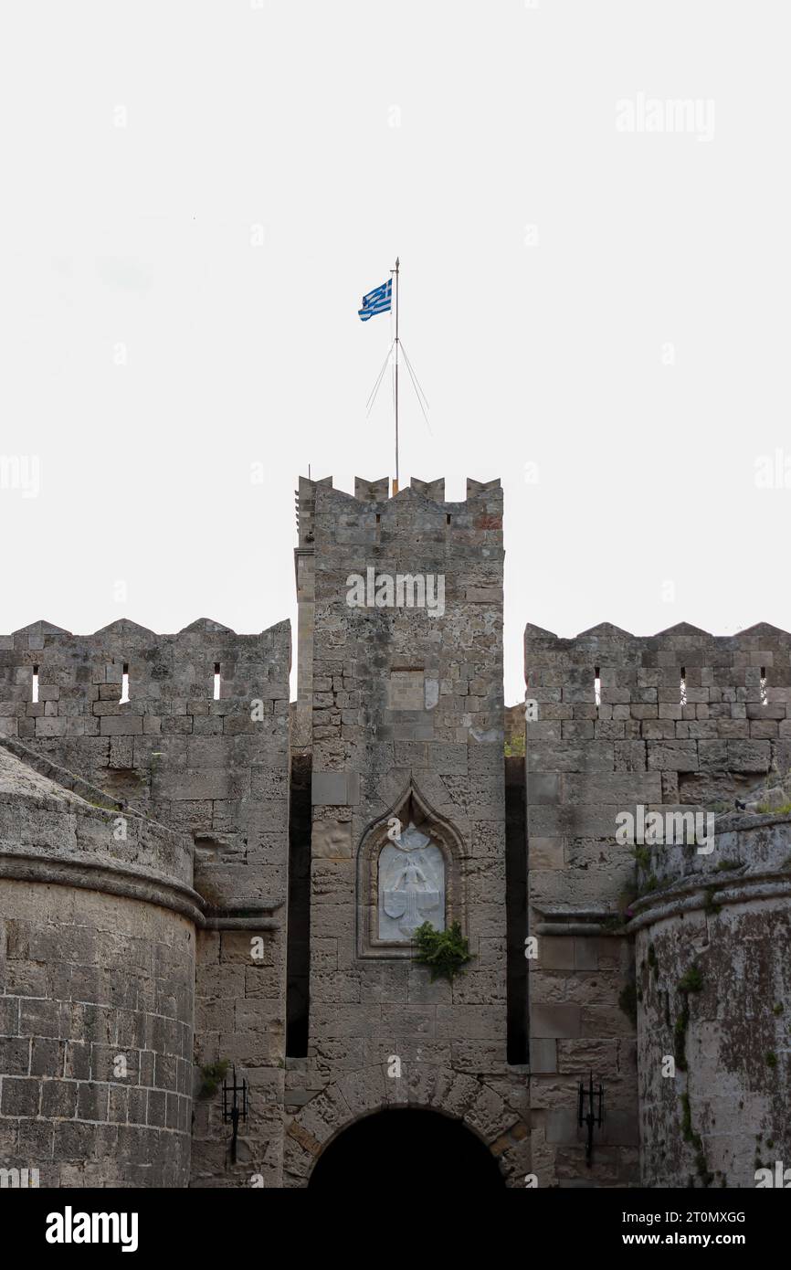 Primo piano della porta di Amboise ambientato nell'angolo nord-occidentale della città medievale di Rodi con la bandiera nazionale greca in cima Foto Stock