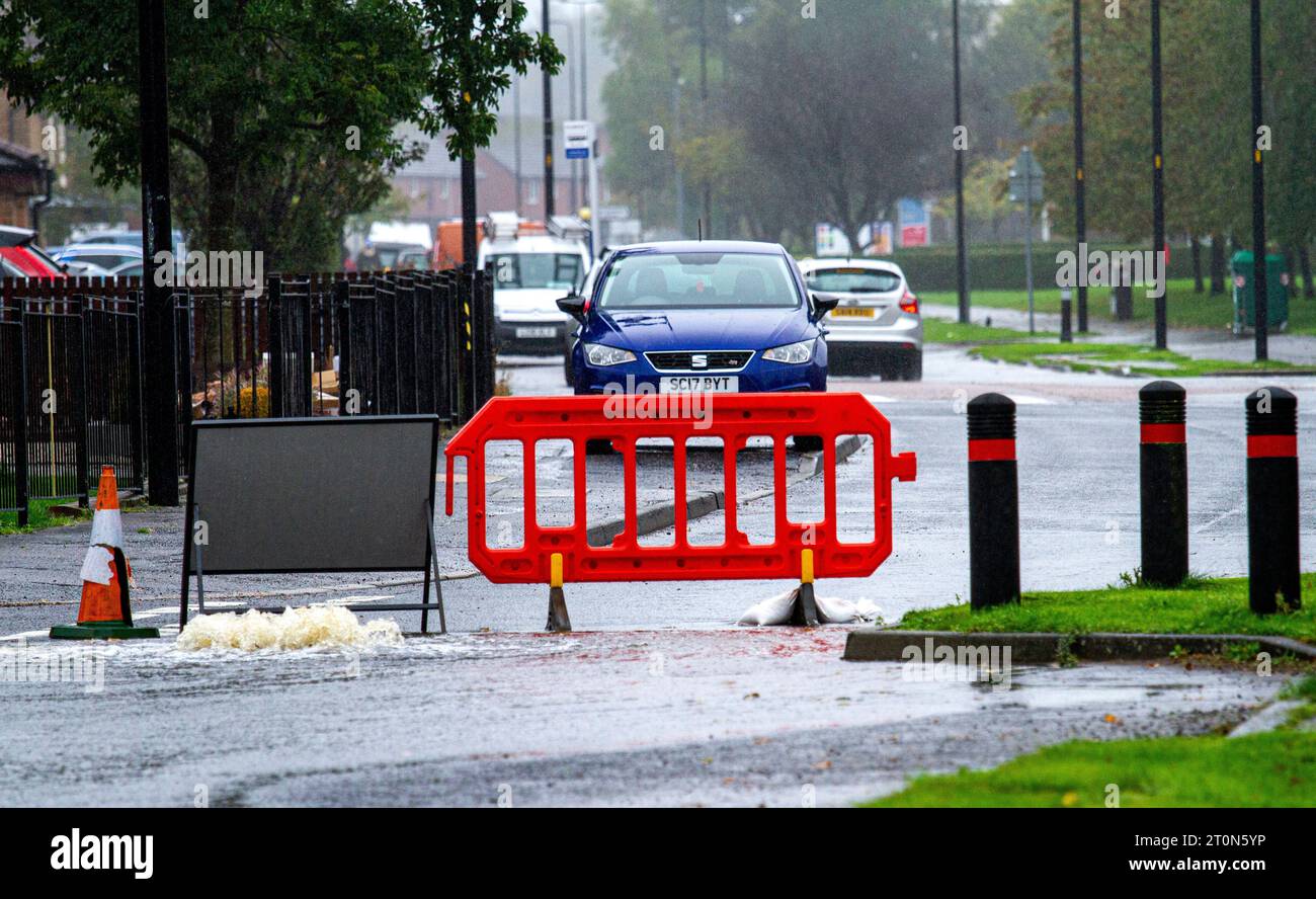 Dundee, Tayside, Scozia, Regno Unito. 8 ottobre 2023. Tempo nel Regno Unito: Le inondazioni sulla MacAlpine Road nel villaggio di Ardler sono il risultato di calate torrenziali notturne a Dundee. La pioggia ha influenzato i viaggi a Dundee, costringendo alcuni servizi di autobus a deviare a causa di strade allagate. Gli automobilisti si vedono guidare attraverso le strade allagate, causando spruzzi d'acqua eccezionalmente alti. Crediti: Dundee Photographics/Alamy Live News Foto Stock