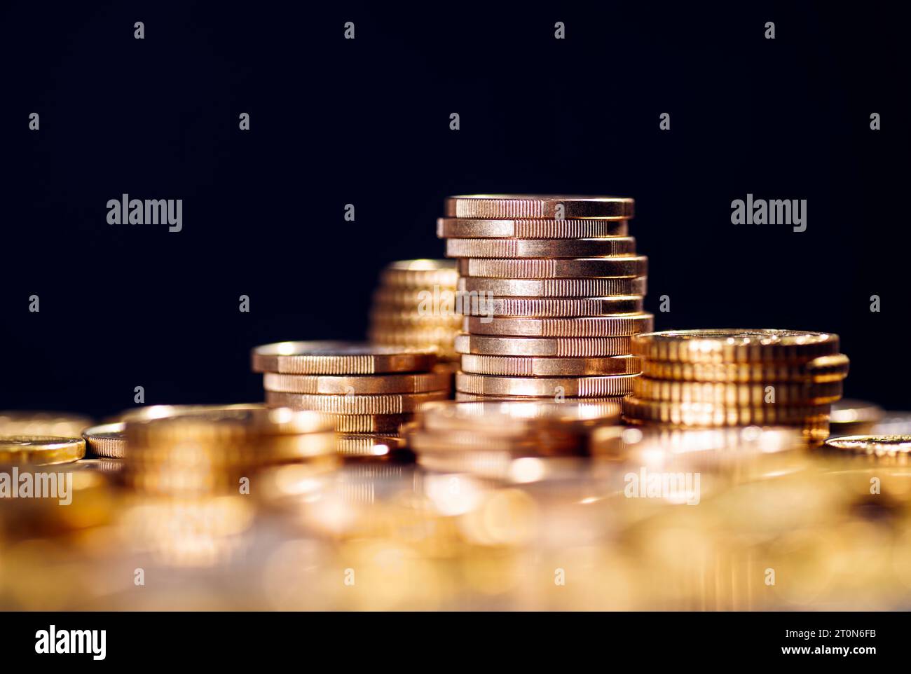 Molte monete impilate con sfocatura in primo piano e spazio di copia Foto Stock