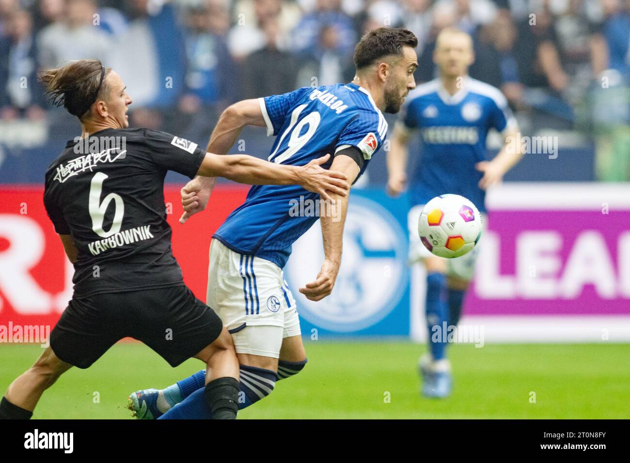 Gelsenkirchen, Germania. 8 ottobre 2023. Calcio: 2. Bundesliga, FC Schalke 04 - Hertha BSC, Matchday 9, Veltins Arena: Schalke's Kenan Karaman (r) e Hertha's Michal Karbownik in azione. Credito: Bernd Thissen/dpa - NOTA IMPORTANTE: conformemente ai requisiti della DFL Deutsche Fußball Liga e della DFB Deutscher Fußball-Bund, è vietato utilizzare o far utilizzare fotografie scattate nello stadio e/o della partita sotto forma di immagini di sequenza e/o serie di foto simili a video./dpa/Alamy Live News Foto Stock