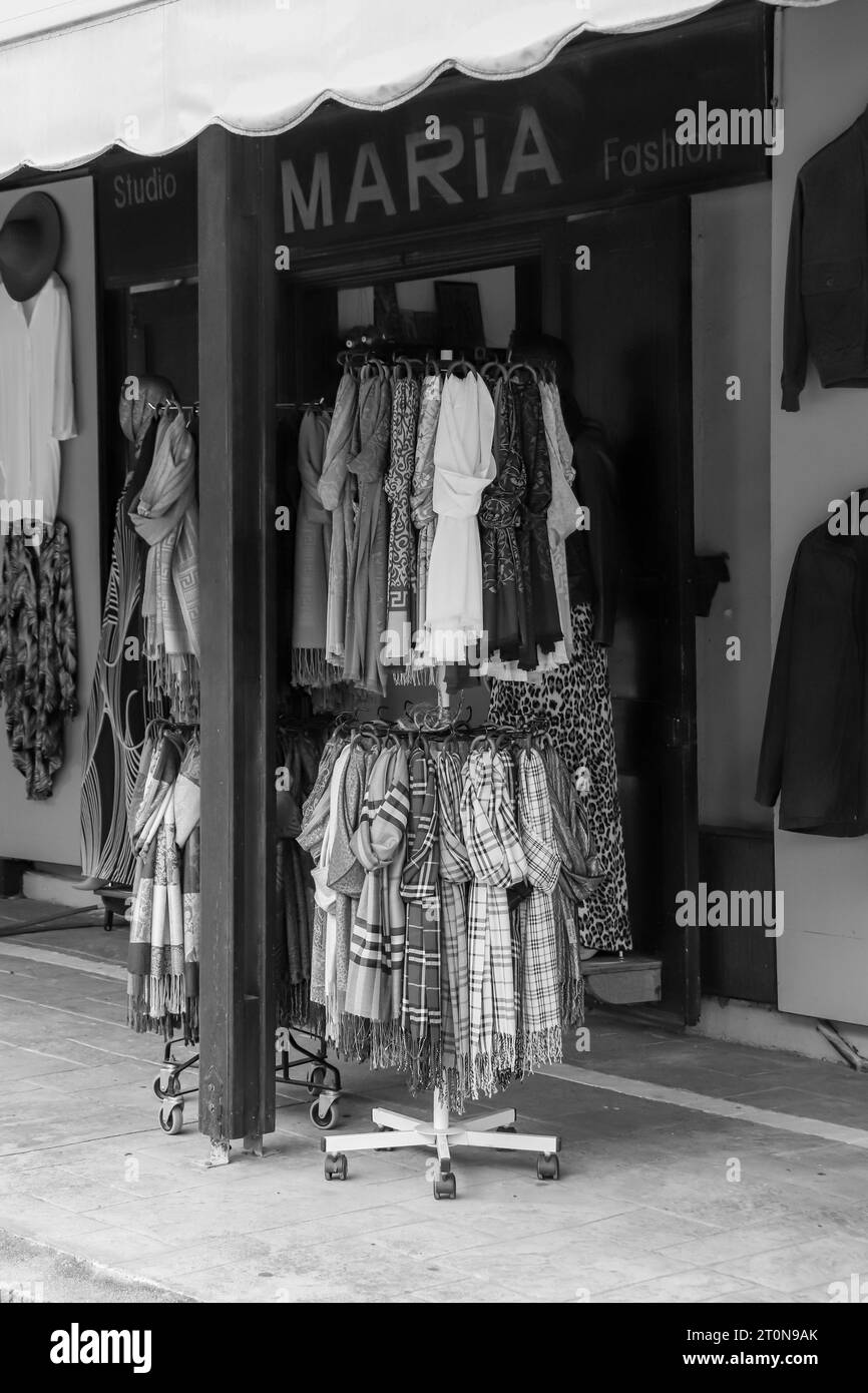 Sciarpe appese a un portabiti circolare a doppio strato esposto nei negozi del mercato della città vecchia di Rodi in bianco e nero Foto Stock