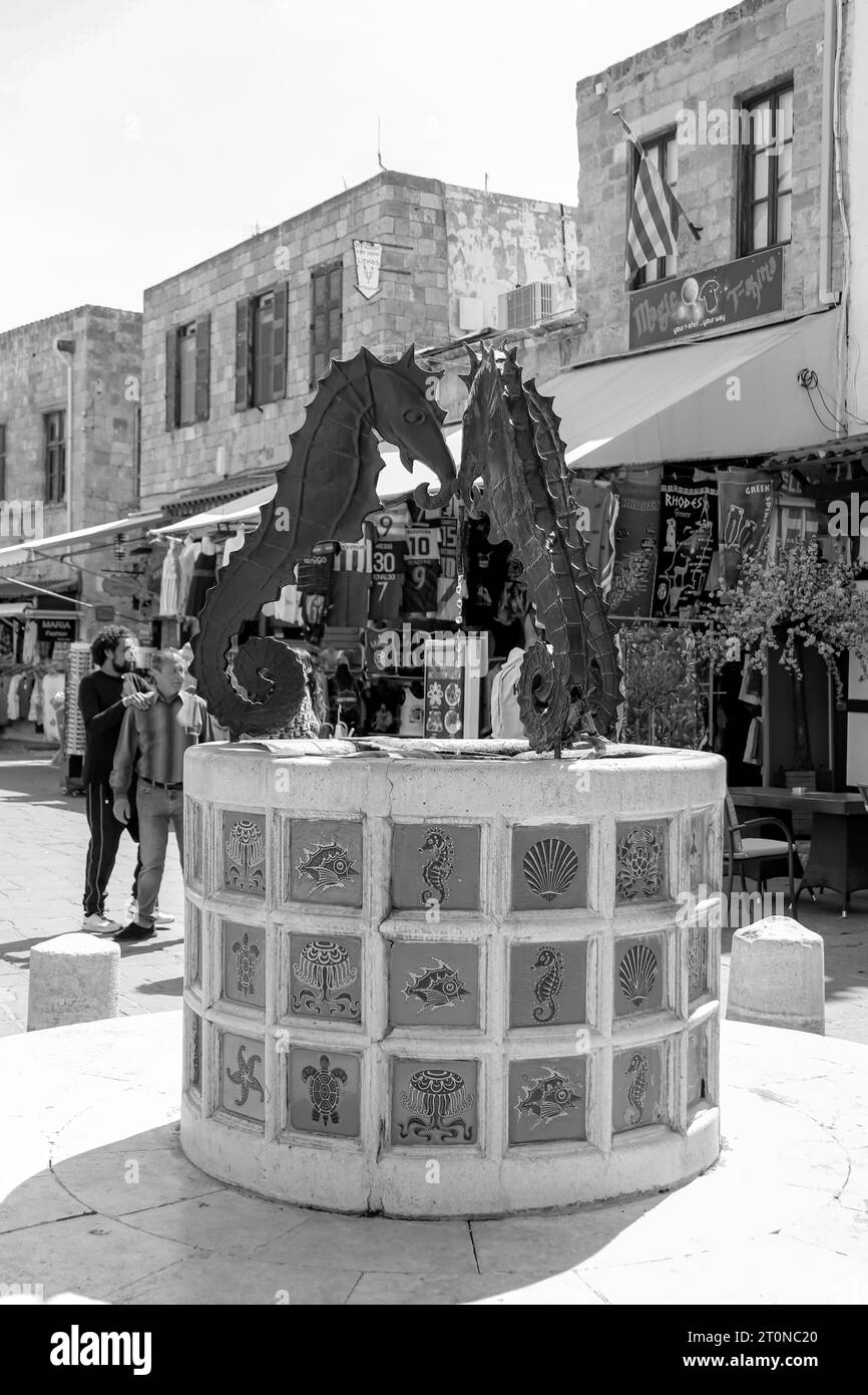 Primo piano della famosa fontana della statua del cavalluccio marino situata nella Piazza dei Martiri ebrei a Rodi, nella città vecchia in bianco e nero Foto Stock