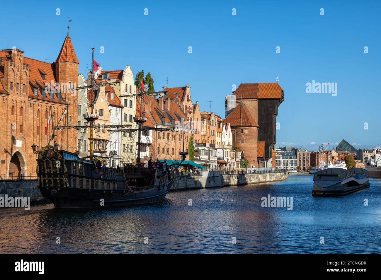 Danzica, Polonia - 11 ottobre 2022 - skyline della città sul lungofiume storico di Long Embankment con la gru e la nave da galeone turistica sul fiume Motlawa. Foto Stock