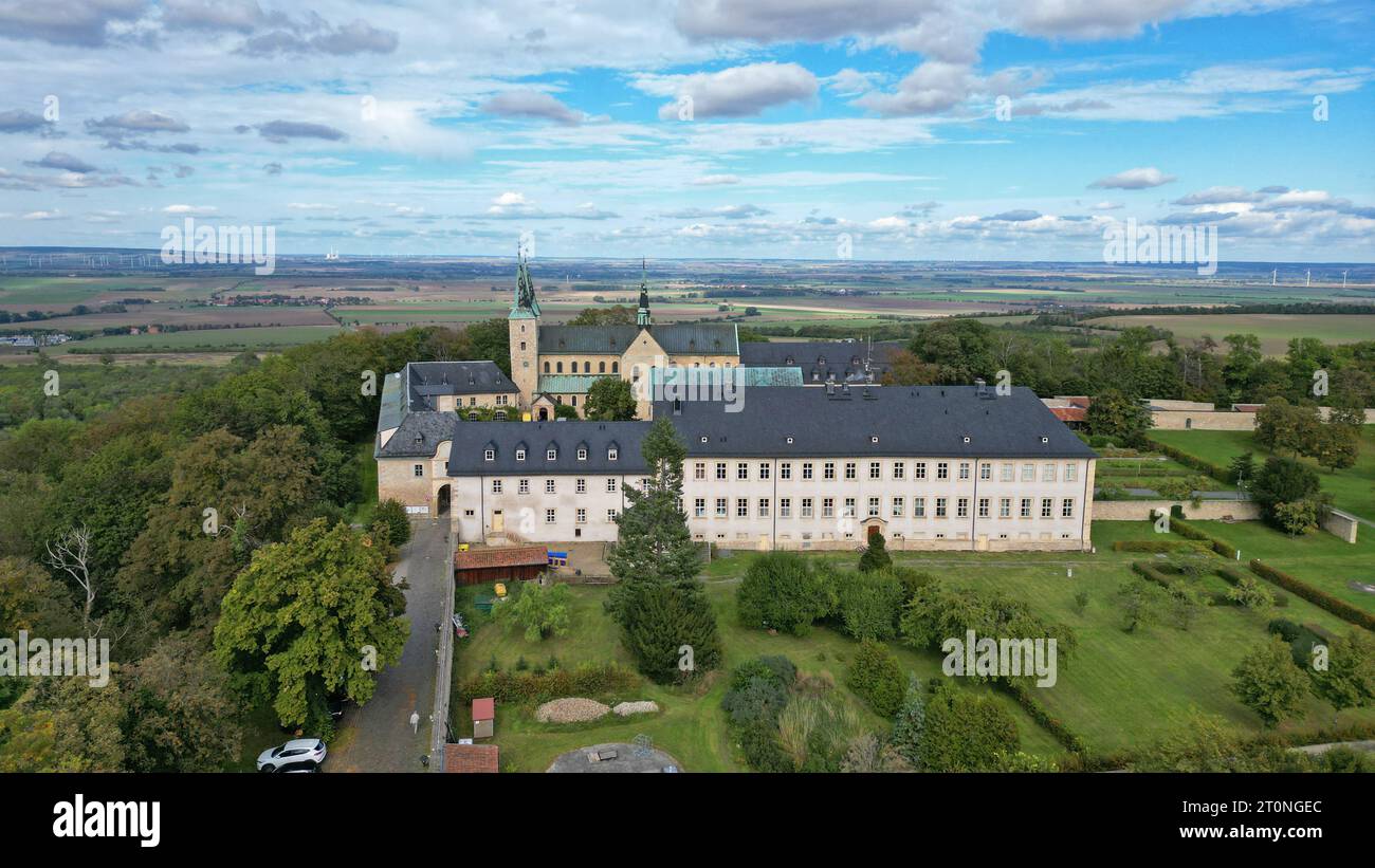 3 ottobre 2023, Sassonia-Anhalt, Huy-Dingelstedt: Il monastero di Huysburg (Priorato benedettino dell'assunzione di Maria in cielo) è un monastero benedettino ad un'altitudine di circa 300 metri sull'Huy, una cresta boscosa a nord dei monti Harz, fotografata con un drone. Il monastero benedettino di Huysburg appartiene alla diocesi di Magdeburgo secondo il diritto ecclesiastico. Huysburg è la prima fermata sulla strada di St James nella regione di Harz e si trova sulla strada meridionale della strada romanica. Oggi Huysburg fa parte di una congregazione benedettina internazionale, è stato il priorato del Benedetto Foto Stock