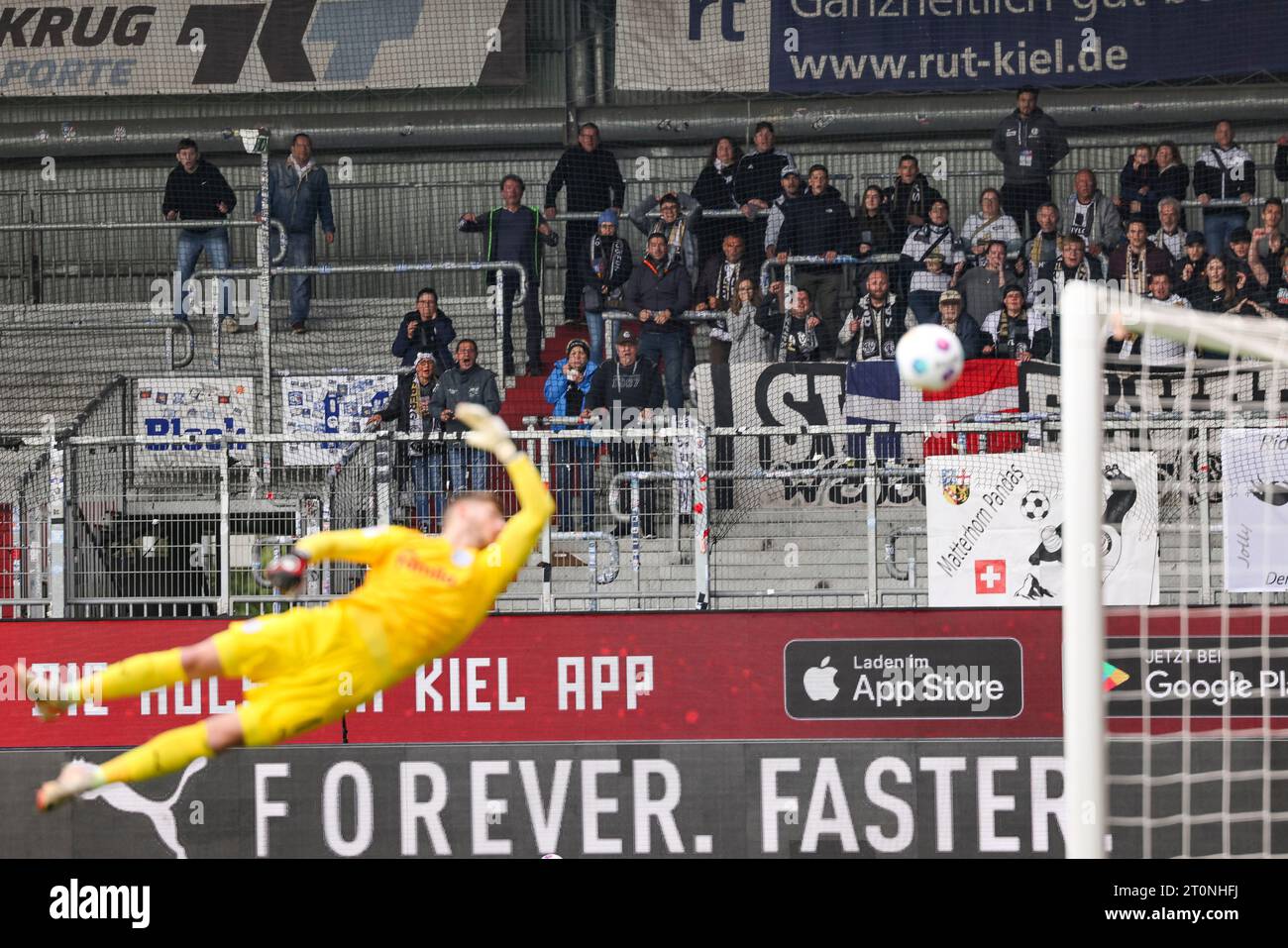 8 ottobre 2023, Schleswig-Holstein, Kiel: Calcio: 2nd Bundesliga, Holstein Kiel - SV Elversberg, Matchday 9, Holstein Stadium. I tifosi di Elversberg fanno il tifo per raggiungere il traguardo 1:1. Foto: Frank Molter/dpa - NOTA IMPORTANTE: In conformità ai requisiti della DFL Deutsche Fußball Liga e del DFB Deutscher Fußball-Bund, è vietato utilizzare o far utilizzare fotografie scattate nello stadio e/o della partita sotto forma di immagini di sequenza e/o serie di foto simili a video. Foto Stock