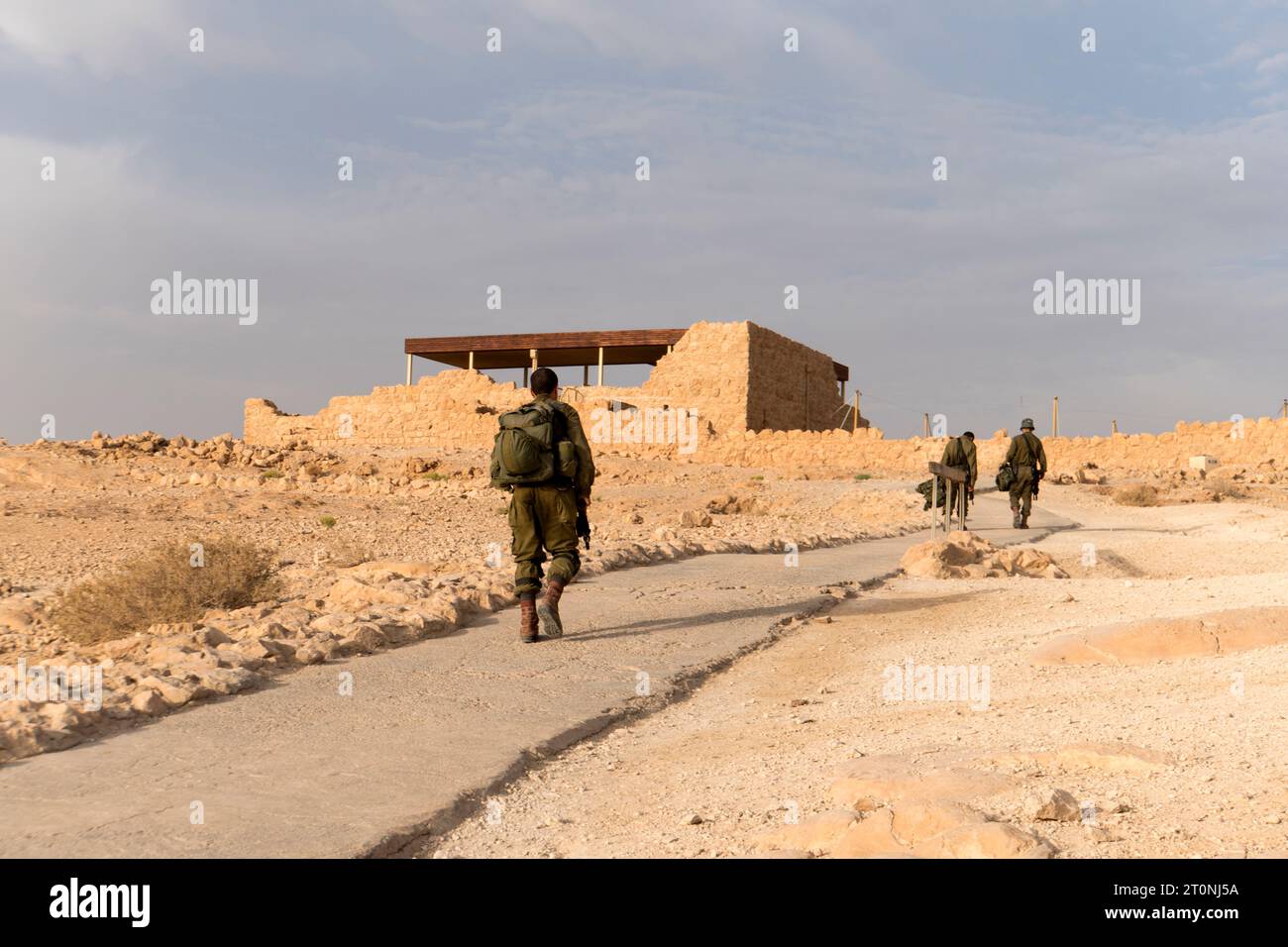 Vista posteriore dei soldati dell'esercito di fanteria che si muovono nel deserto. Sabbia e cielo blu sullo sfondo di uomini militari israeliani nella fortezza. Uomini di servizio stanchi con noi Foto Stock