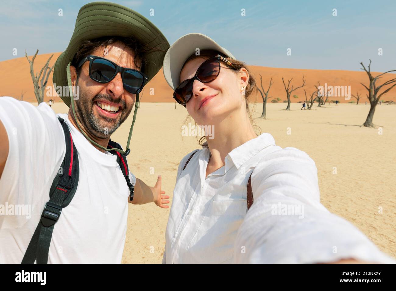 Coppia adulta prendendo selfie sulle dune di sabbia a Sossusvlei nel deserto del Namib, Namib Naukluft National Park, la principale destinazione di viaggio in Namibia, Africa. Foto Stock