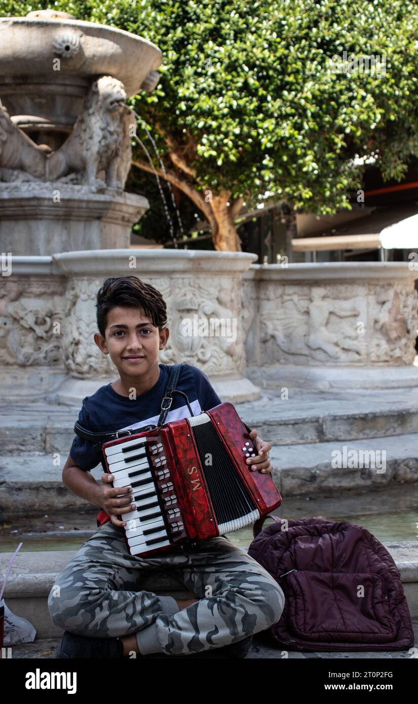 Un ragazzo che suona una fisarmonica a Iraklio, Creta Foto Stock