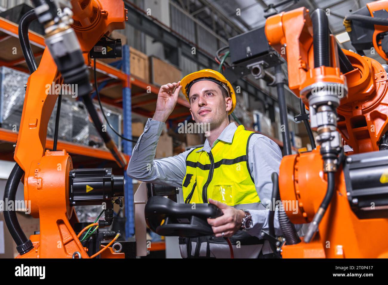 Uomo ingegnere moderno intelligente che utilizza la moderna tecnologia robotica. Configurazione del braccio di saldatura robotizzato nel processo di produzione dell'automazione in fabbrica Foto Stock