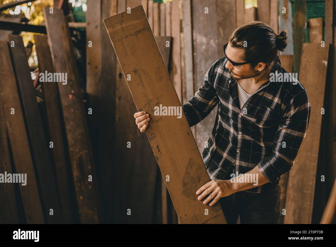 La scelta dei lavoratori dei costruttori di mobili da falegname seleziona il materiale in legno dal pelo per trovare il pezzo in legno adatto per nuovi progetti. Foto Stock