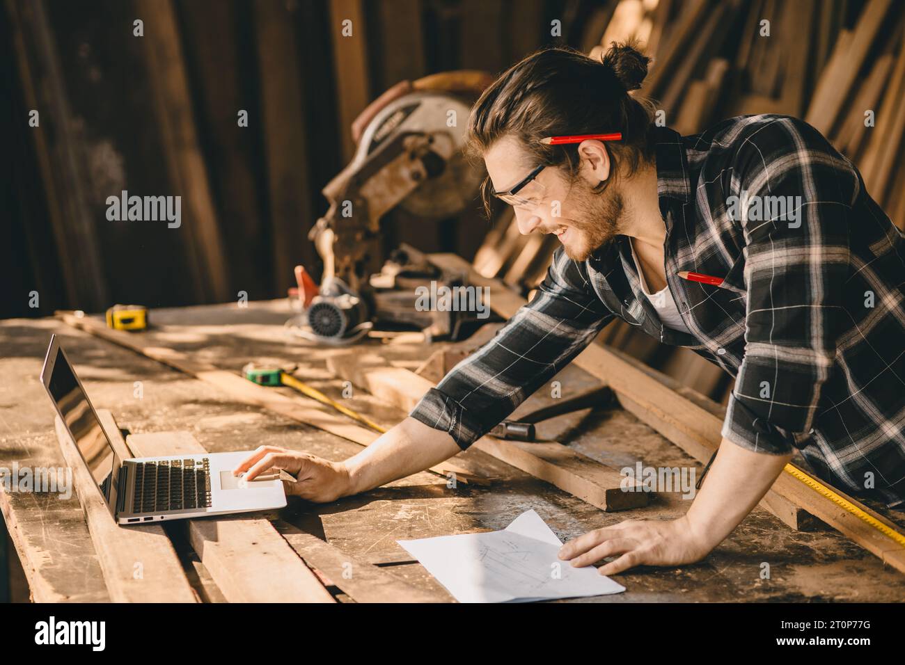 Carpenter man che utilizza software per computer portatili di tecnologia moderna ha aiutato a disegnare nuovi progetti di mobili in legno Foto Stock Carpenter man che utilizza software per computer portatili di tecnologia moderna ha aiutato a disegnare nuovi progetti di mobili in legno Foto Stock