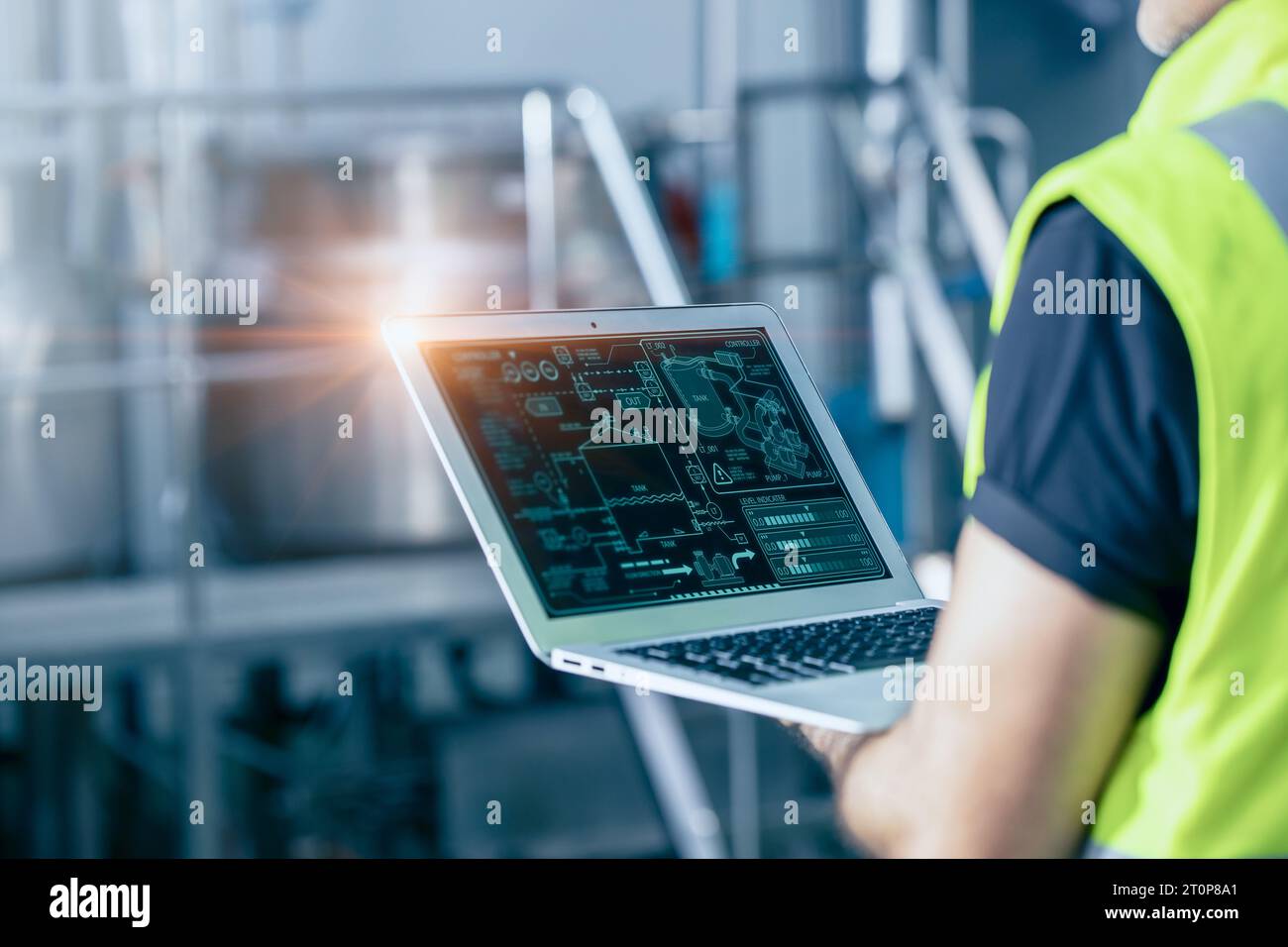 Ingegnere con software ad alta tecnologia per computer portatili per l'automazione industriale controlla il monitor di lavoro della macchina di servizio. Foto Stock