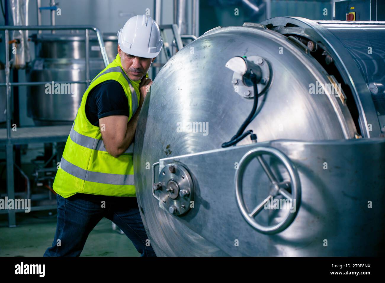 Tecnico ingegnere lavoratore maschio che lavora nella sala caldaia per il controllo della routine di manutenzione del tubo del gas nella fabbrica industriale Foto Stock