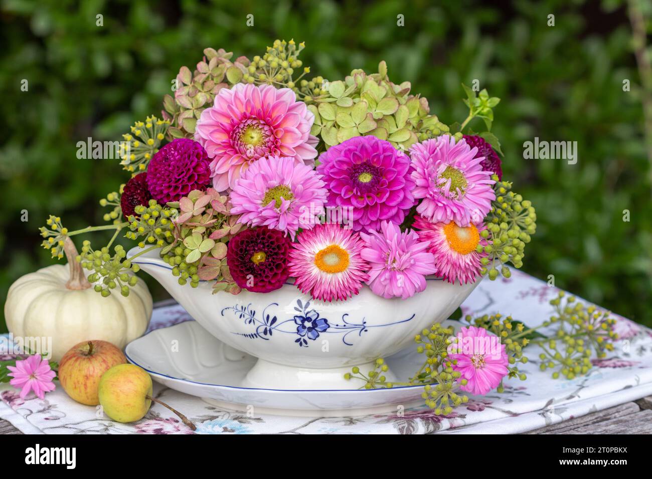 composizione floreale con dahlia rosa, aaster, fiori di fragola e fiori di ortensia in barca con salsa Foto Stock