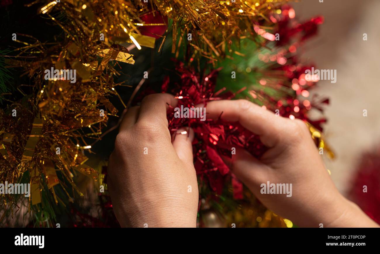 Mani femminili che decorano l'albero di Natale Foto Stock