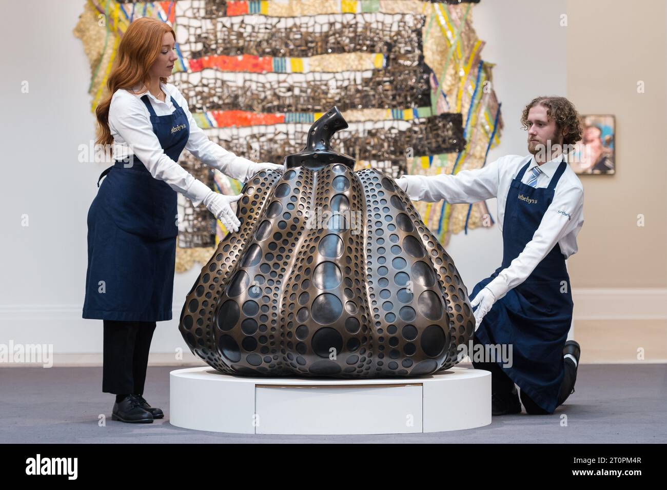 Londra, Regno Unito. 6 ottobre 2023. LONDRA, REGNO UNITO - 06 OTTOBRE 2023: I membri dello staff della Gallery tengono un'opera d'arte di Yayoi Kusama, Pumpkin (S), 2014, stima £ 2.400.000 - 4.000.000, durante una visita fotografica alla casa d'aste Sotheby's che mostra i punti salienti delle vendite della Frieze Week a Londra, Regno Unito il 6 ottobre 2023. Le opere d'arte saranno esposte alla casa d'asta Sotheby's tra il 7 e l'11 ottobre prima di essere offerte durante le aste serali Now e Contemporary il 12 ottobre. (Foto di Wiktor Szymanowicz/NurPhoto) credito: NurPhoto SRL/Alamy Live News Foto Stock